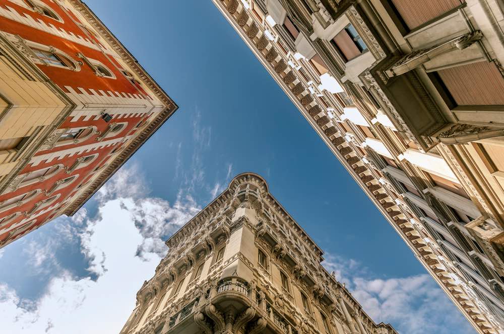 Facades of buildings at an intersection, viewed from below. Strong foregrounds and backgrounds coupled with thoughtful angles create a perfect composition following the Rule of Thirds.