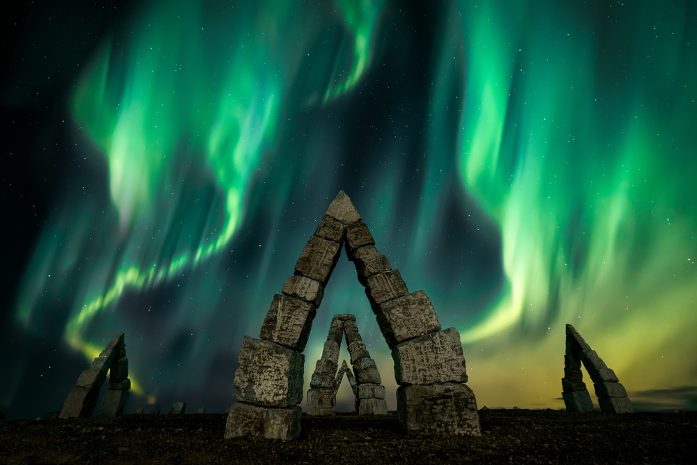 Fiery green dancing aurora borealis over Arctic Henge, Iceland.