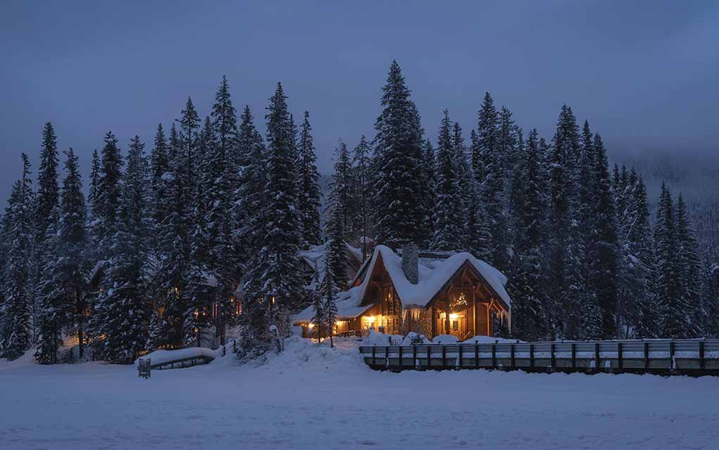 blue hour photo of snow-covered house.
