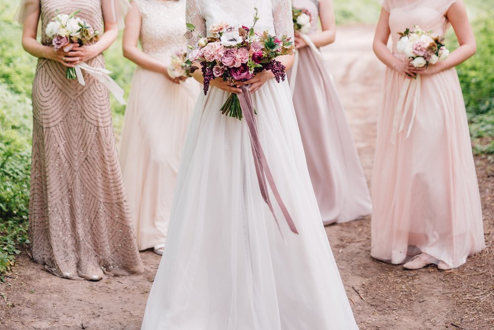A group of bridesmaids stand behind the bride.