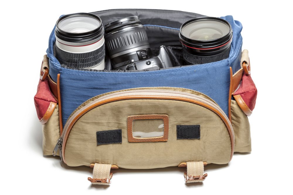 A camera bag loaded with photography gear. Camera body and some lenses visible.