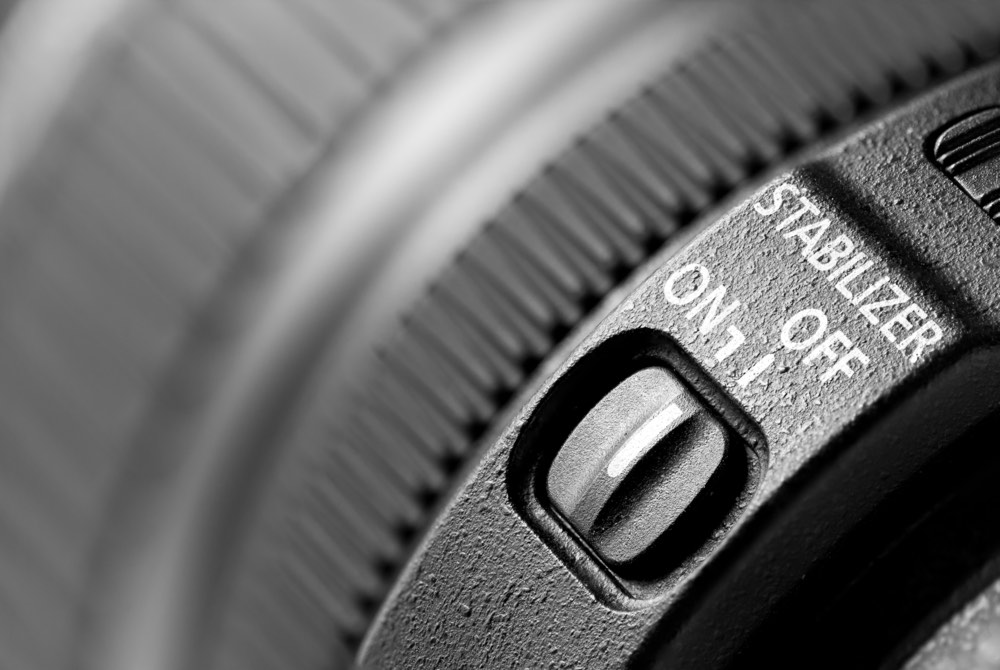 Close-up view of a camera lens showcasing the on-off switch for the optical image stabilization (OIS) feature.