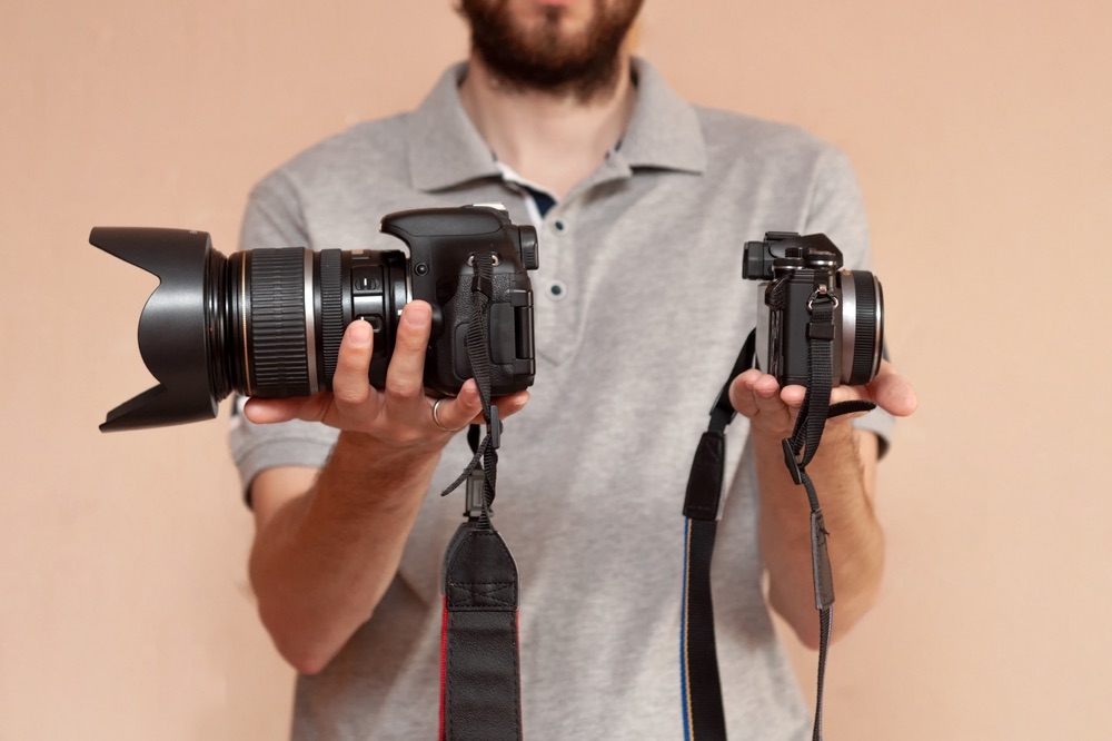 A side-by-side comparison of two cameras, showcasing the size difference between DSLRs and compact mirrorless gear.