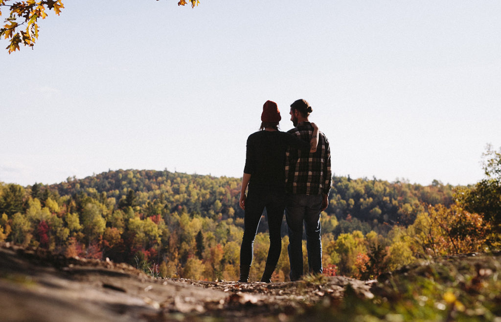 wide shot of couple admiring an autumn landscape together