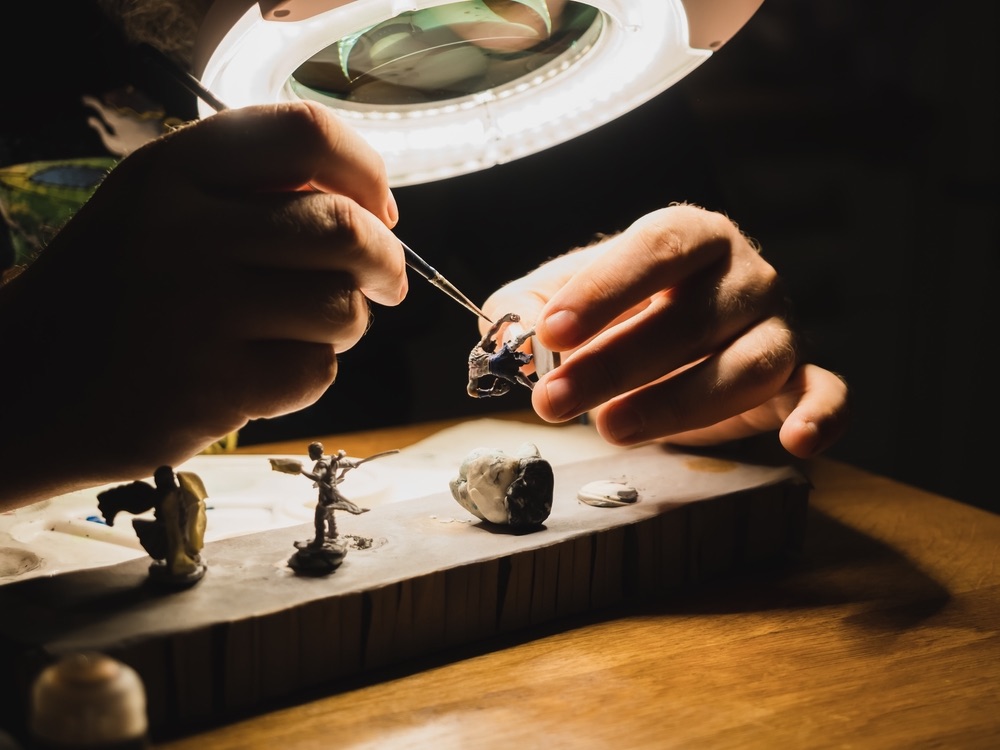 Hand-painting and piecing together miniature figurines for photography. Creative DIY concept of making your own props and subjects.