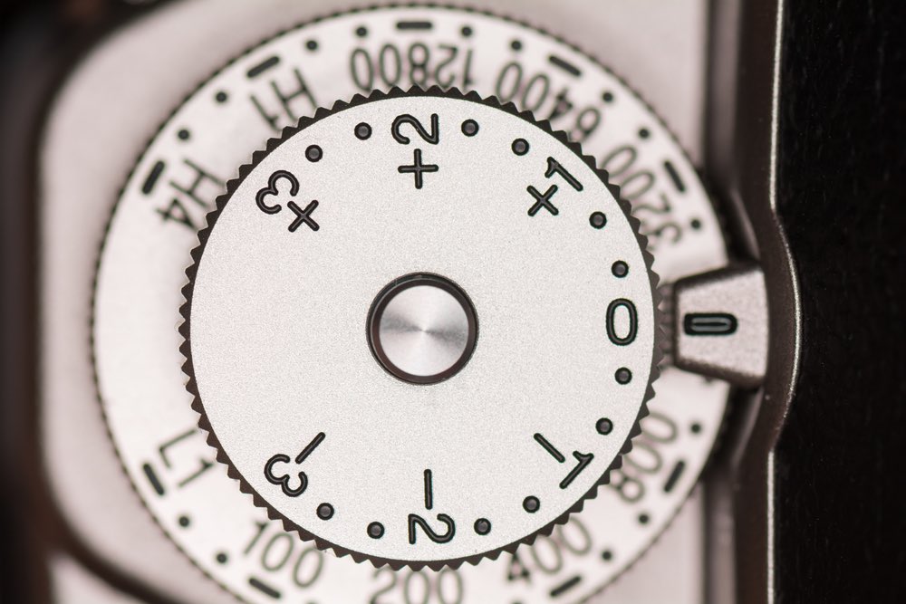 Close-up view of exposure compensation dial on a contemporary mirrorless camera.