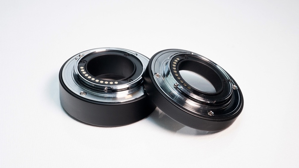 A pair of extension tubes for macro photography. White background.
