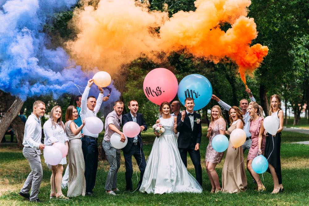 A family poses for a photograph using balloons and smoke grenades.