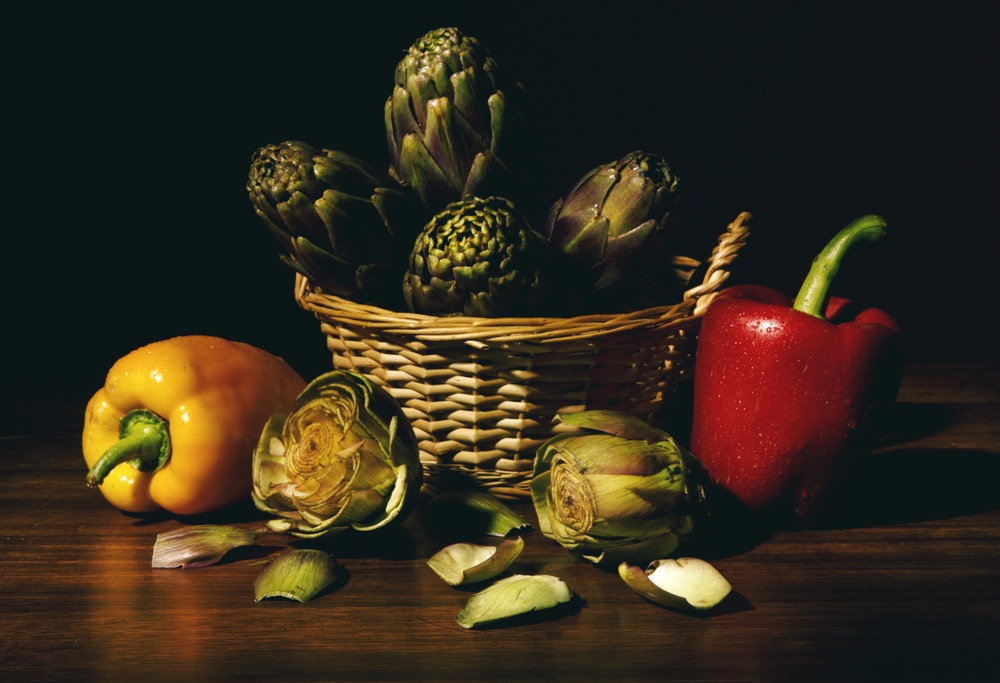 Still life of vegetables in a basket and on a wooden surface. Skillful use of fill flash exposure compensation created a moody, low-key look.