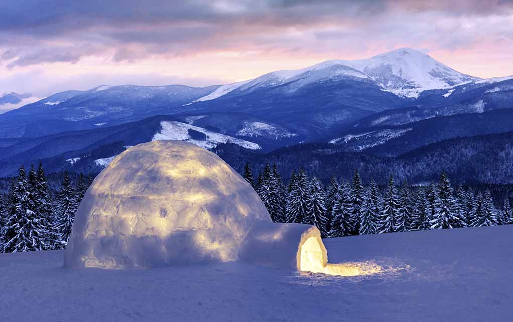 igloo with snowy mountains.