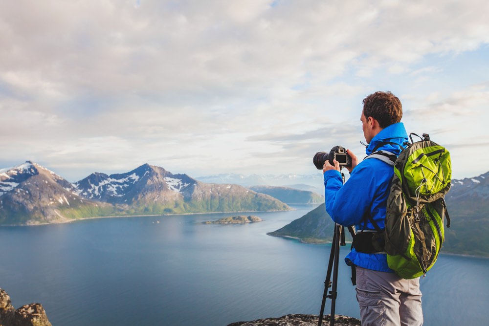 A landscape photographer uses a tripod to take a shot of some scenery.