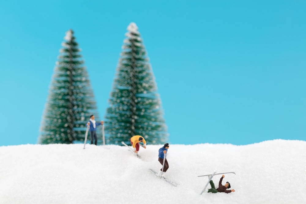 A group of miniature skiers snowboarding on an outing with mixed success. A winter landscape group scene realized entirely with miniature props.