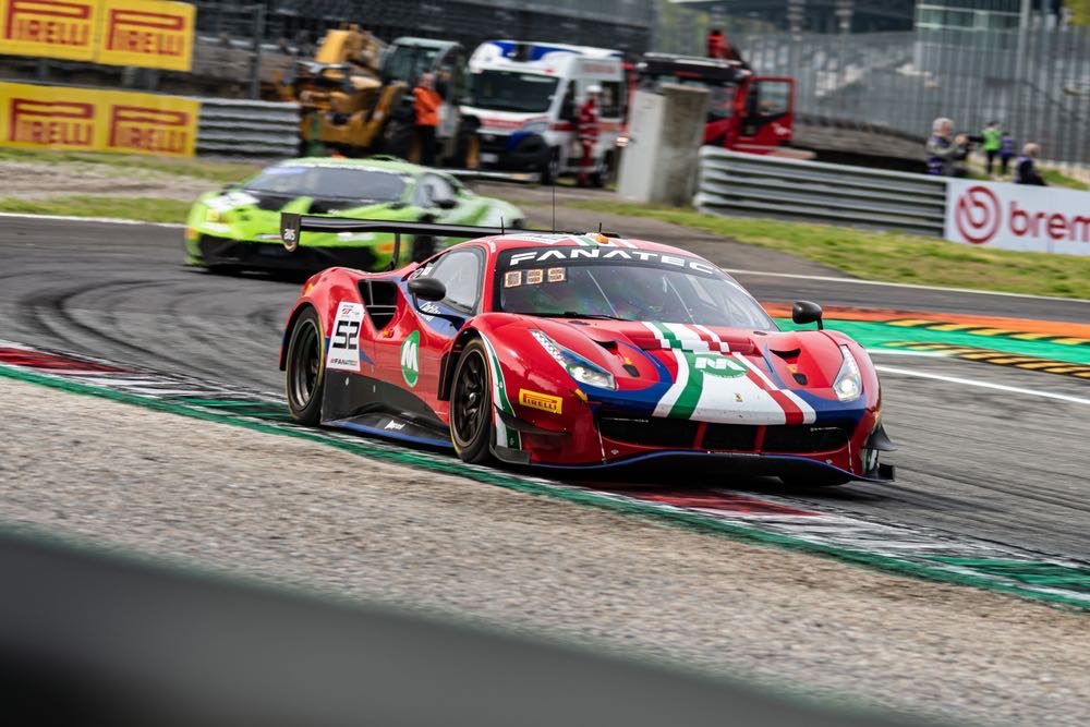 Two racecars face off at the Monza circuit in Italy. Motorsports photography in action.