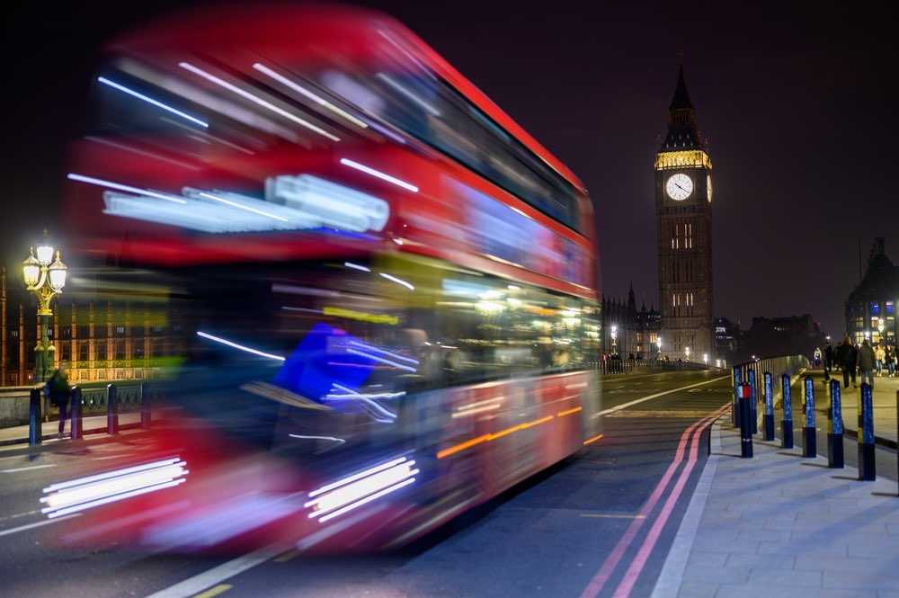 A London double-decker bus driving by at high speed. Nighttime long exposure in candid street photography. An example of the 'decisive moment' in action.