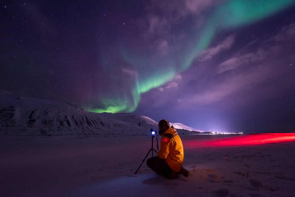 A photographer shooting the northern lights in Svalbard, Norway.