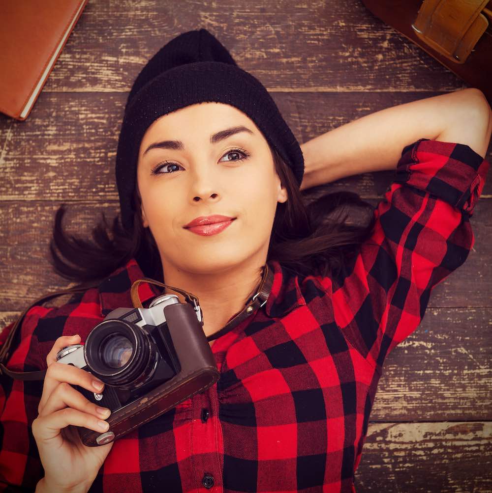 portrait of brunette holding a camera.