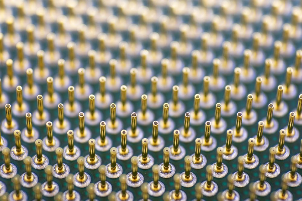 Close-up photograph of CPU pins, showing interesting geometric patterns and depth of field effects.