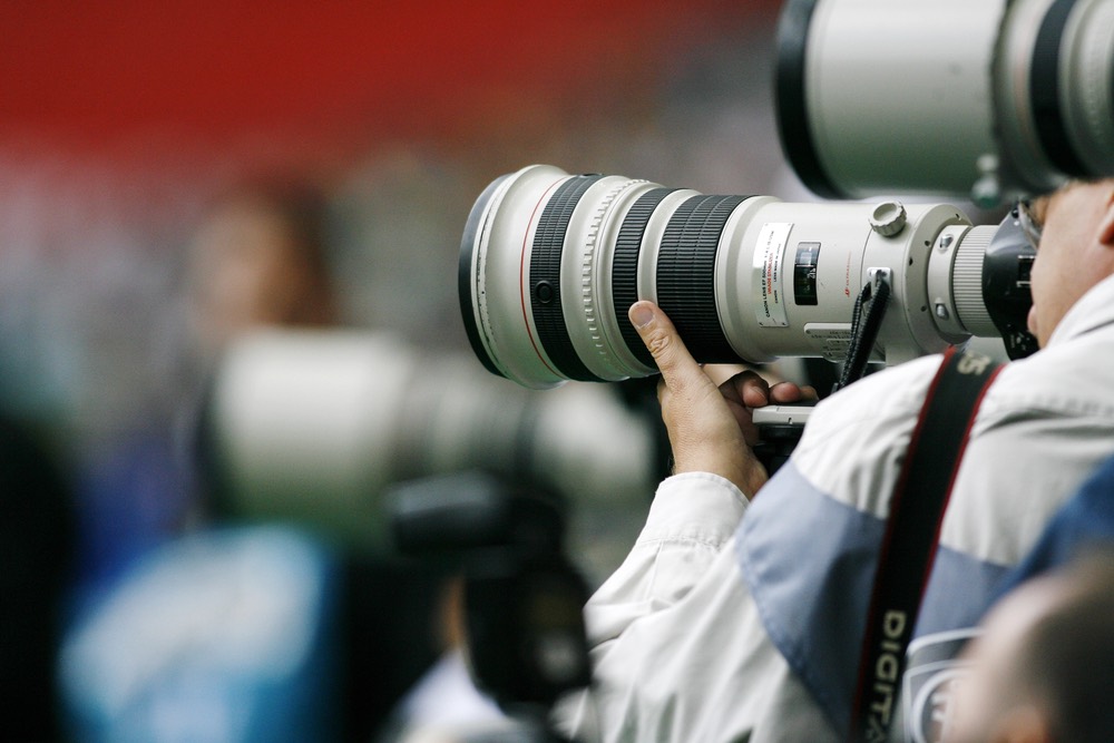 Sports photographers shooting with long telephoto lenses on tripods. An example of stabilization in sports photography.