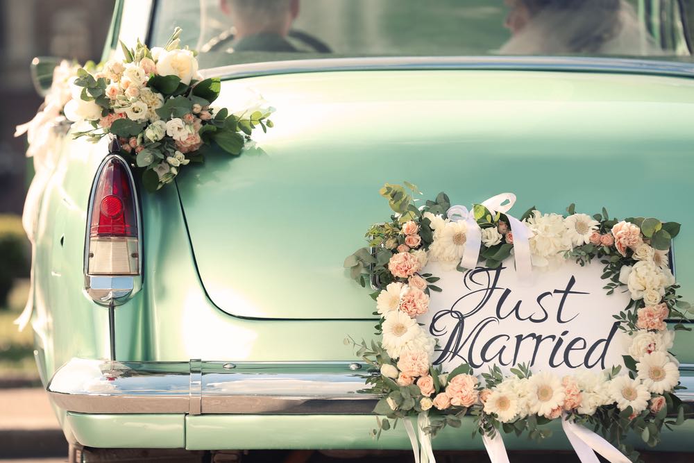 This photo is of a vintage car with a "just married" sign on the back.