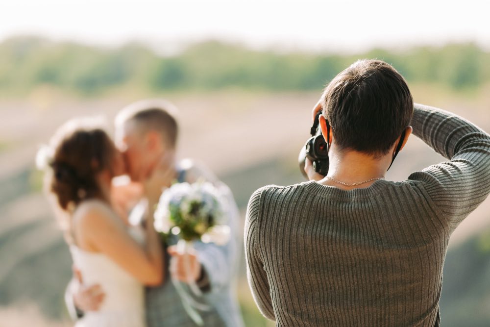 wedding photographer taking photos of bride and groom.