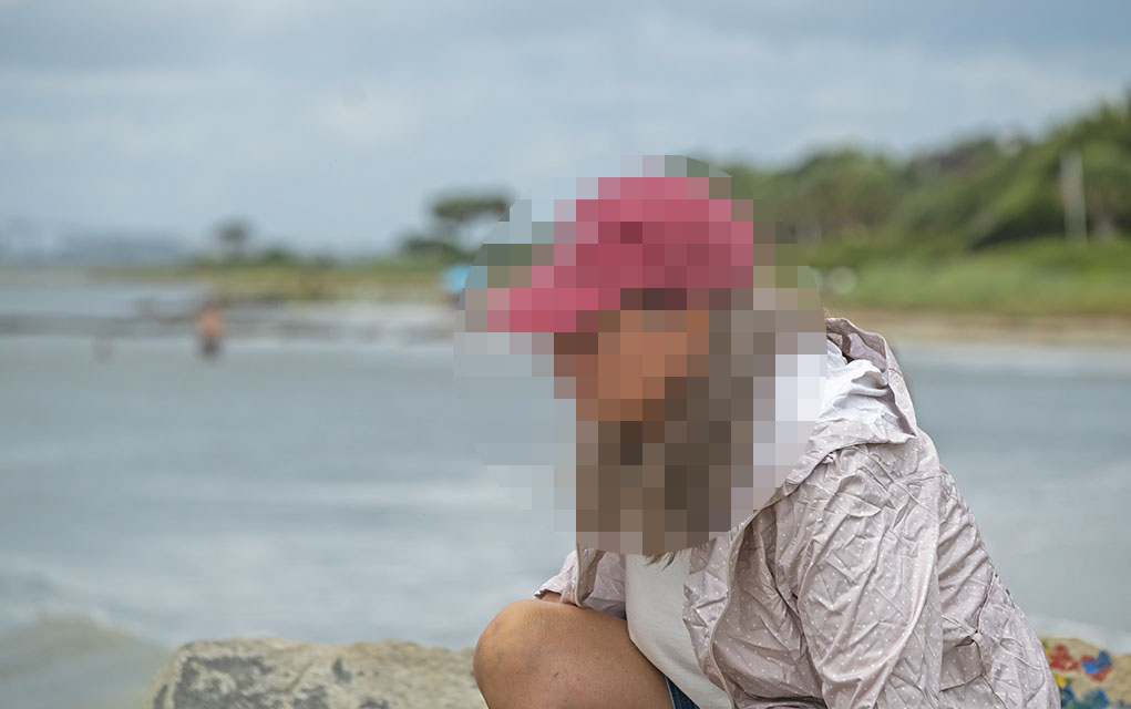 woman's face obscured with pixelization.