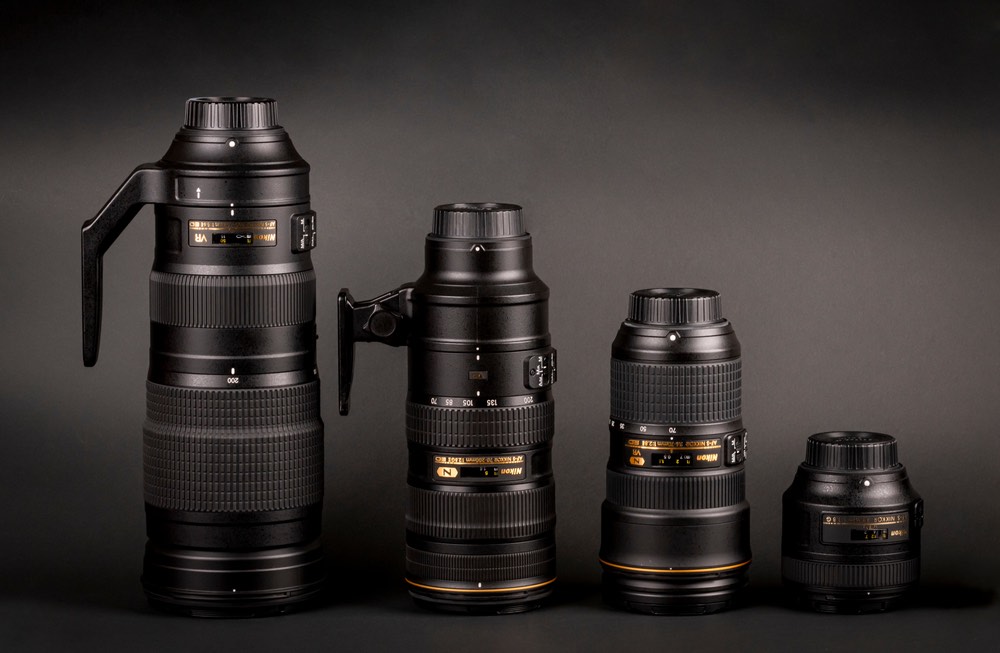 A side-by-side lineup of different Nikon DSLR lenses. Three zooms and one prime lens. Stark size difference.